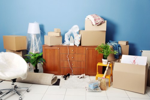 Removalists carrying furniture through a Belmont property with narrow access