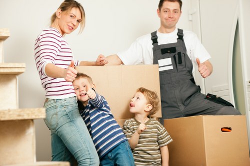 Movers handling furniture through a shared entrance in Belmont